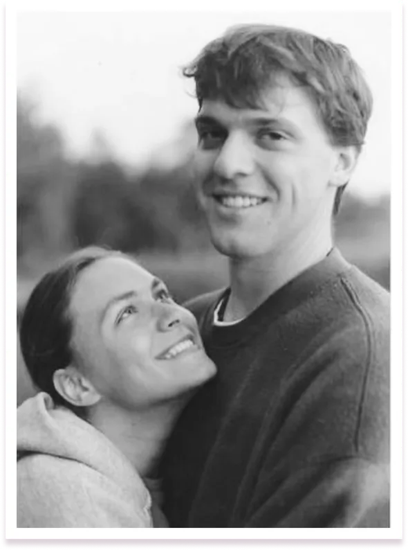 Image-11.png A cheerful black and white photo of a young couple, with the woman looking up affectionately at the smiling man, outdoors.